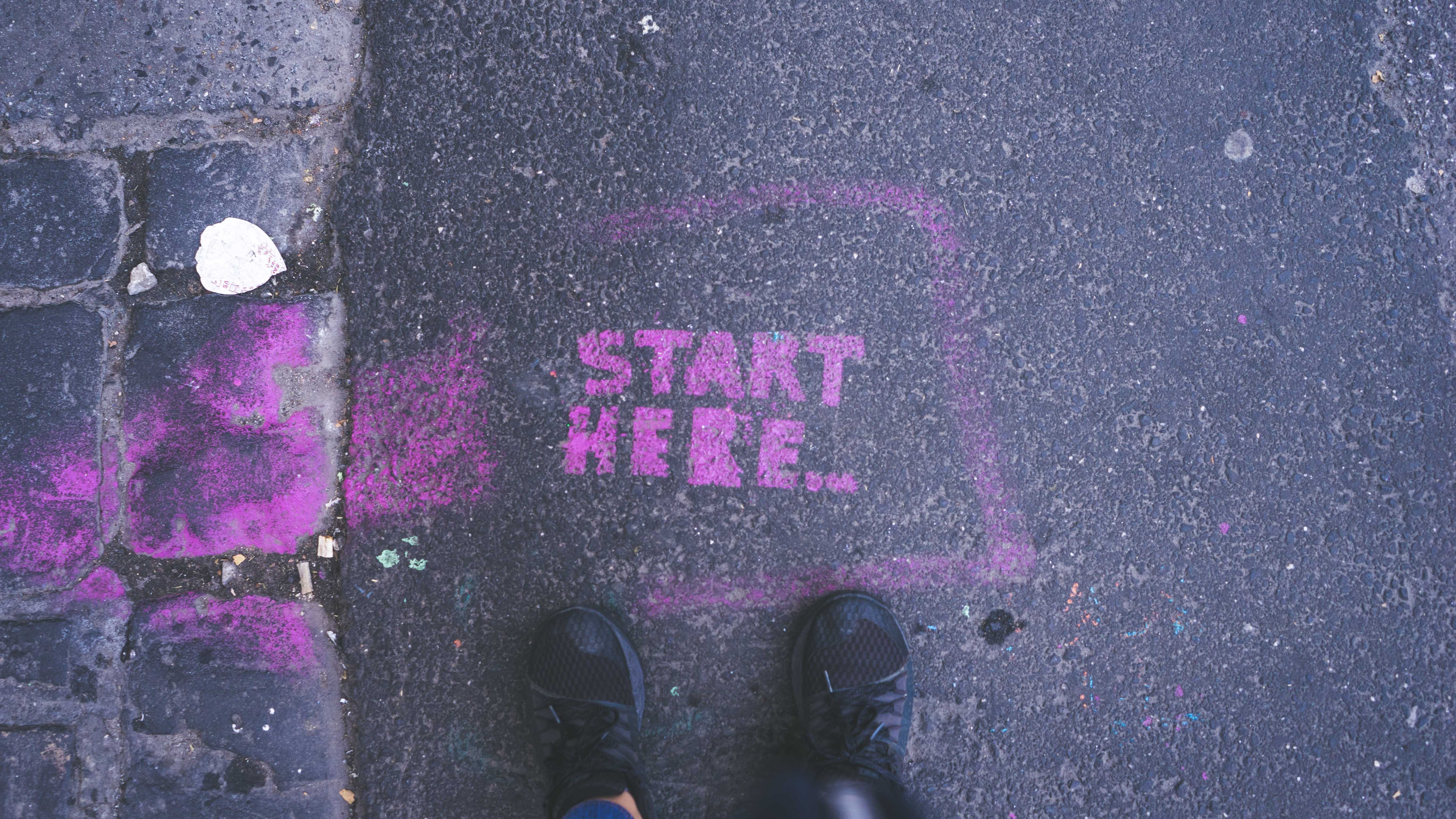 Aufschrift auf Straße: Start here
